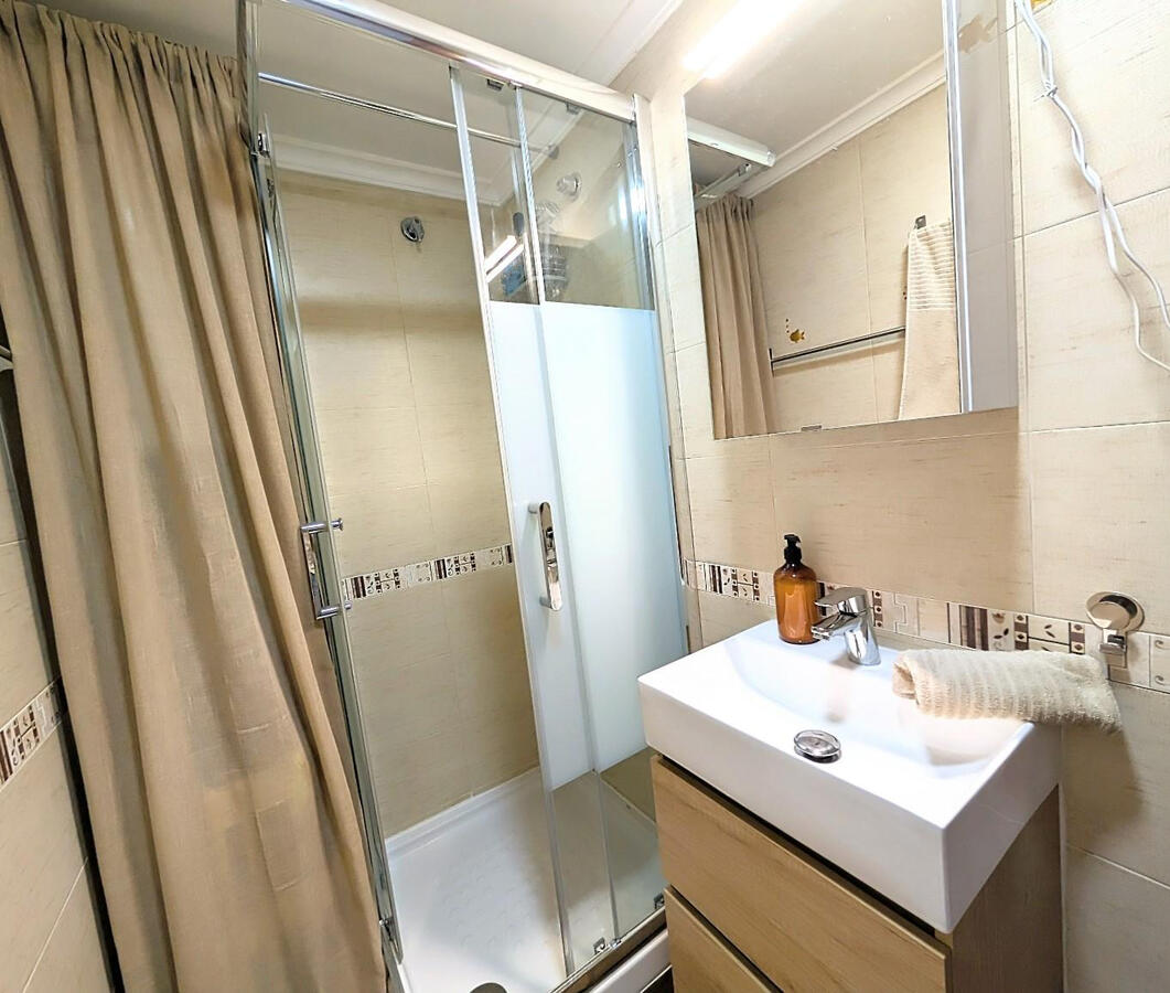 Modern bathroom with walk-in shower, sink and mirror in Apartment Vali Torrevieja