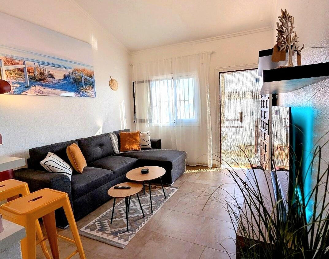 Bright living room – Apartment Vali Torrevieja Spacious living room in Apartment Vali Torrevieja with comfortable sofa, coffee tables and access to sunny terrace